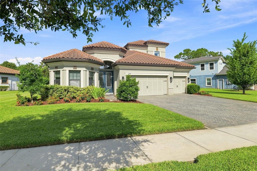 A single-story house with a tile roof, beige stucco exterior, and a paved driveway — 2967 BARBOUR TRAIL, ODESSA, FL