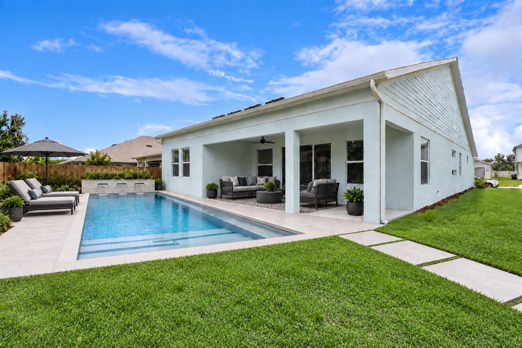 An aerial view shows a suburban house with a brown shingled roof and backyard patio — 19307 BANFIELD PLACE, ORLANDO, FL