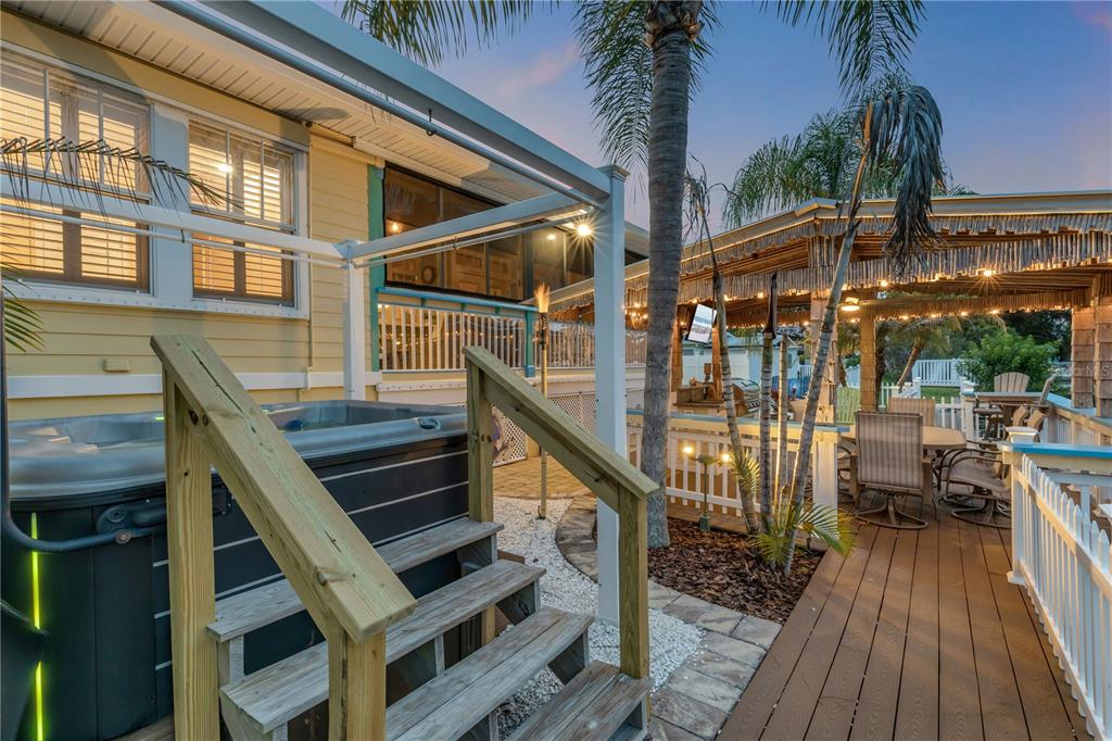 A grassy front yard features a palm tree, a small sapling, and a white fence — 521 S PENINSULA AVENUE, NEW SMYRNA BEACH, FL