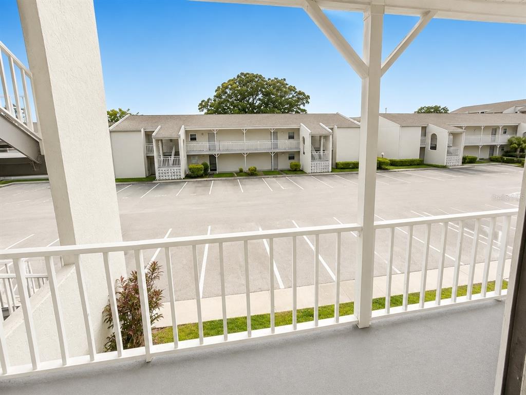 A view from a balcony overlooking an apartment complex parking lot and building exterior — 2625 STATE ROAD 590 UNIT 1123, CLEARWATER, FL