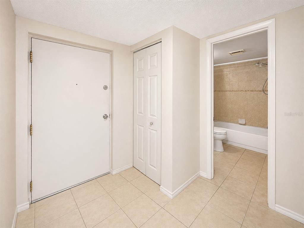 An entryway with tile flooring, a white door, a closet, and a bathroom doorway — 2625 STATE ROAD 590 UNIT 1123, CLEARWATER, FL