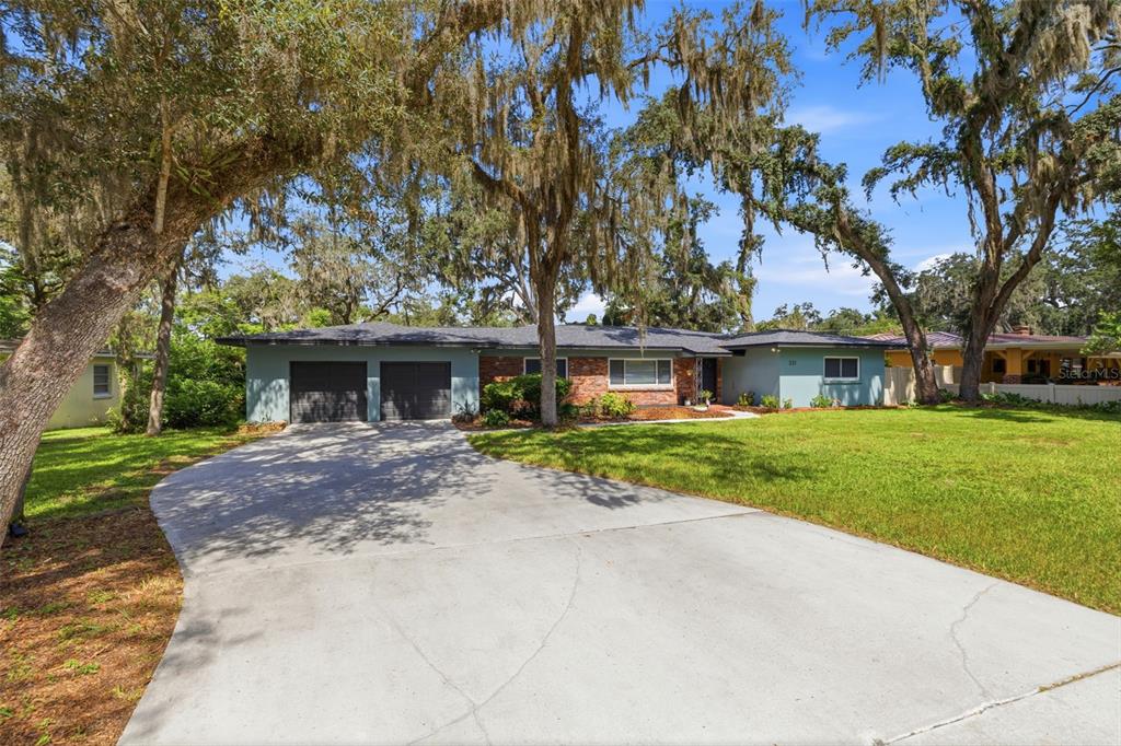 A single-story house with a two-car garage, brick accents, and a large front lawn — 331 SUNNYSIDE ROAD, TEMPLE TERRACE, FL