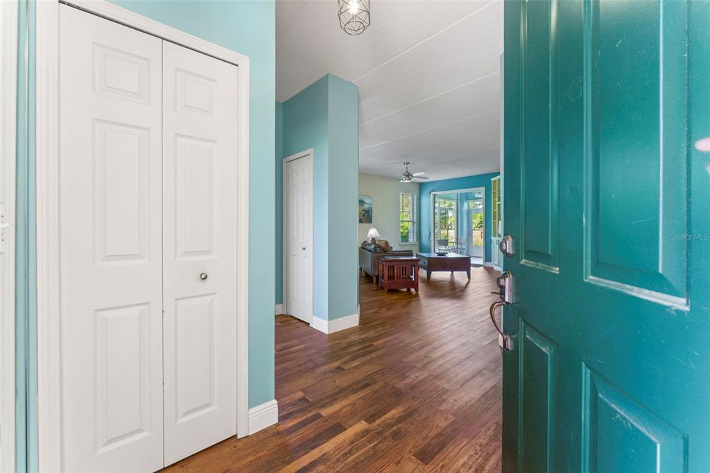 An open doorway reveals a foyer with light blue walls, wood flooring, and a living area — 710 AUGUSTA CIRCLE UNIT 11A, ST AUGUSTINE, FL