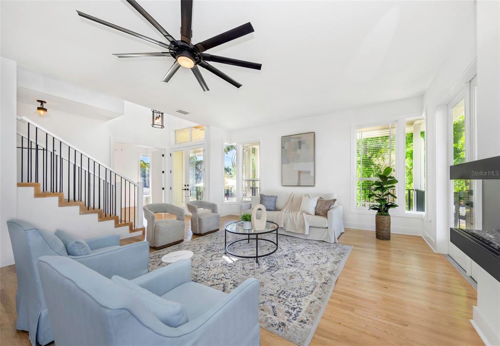 A bright bedroom features a king bed, a ceiling fan, and large windows overlooking water — 606 INDIANA AVENUE, CRYSTAL BEACH, FL