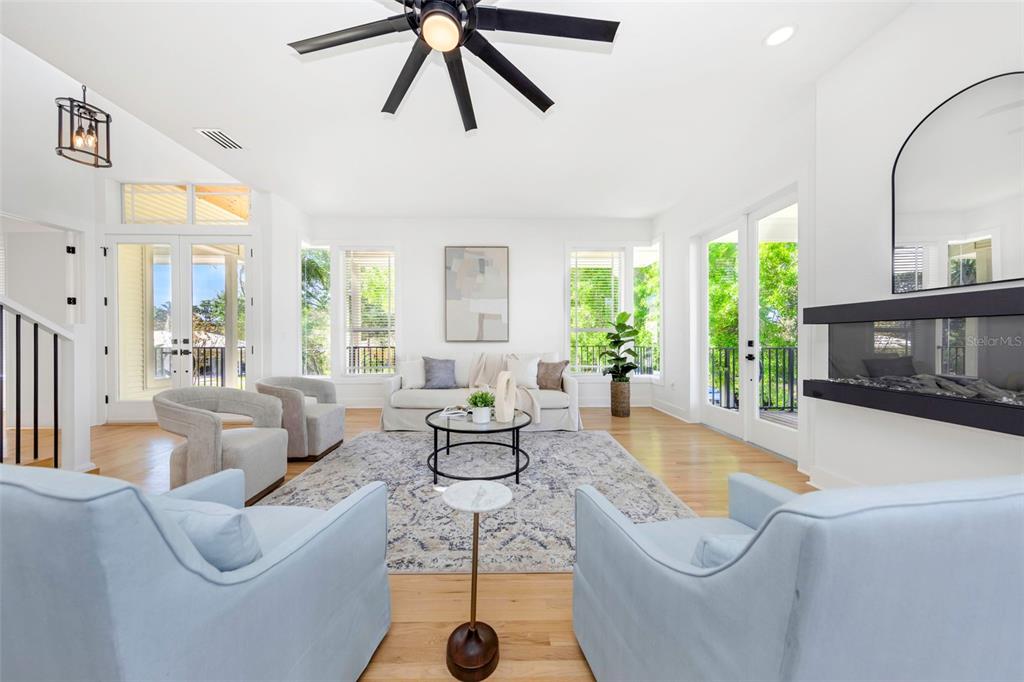 A modern kitchen features white cabinets, a large island with a gas range, and hardwood floors — 606 INDIANA AVENUE, CRYSTAL BEACH, FL