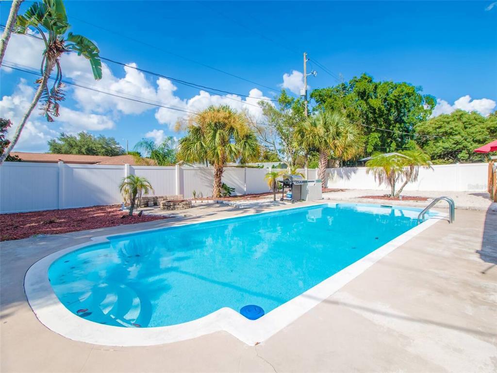 A rectangular swimming pool sits in a backyard enclosed by a white vinyl fence — 4401 LENMORE STREET, ORLANDO, FL