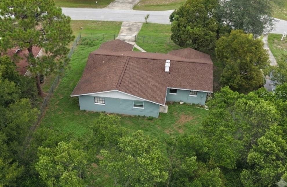 An aerial view of a single-story house with a brown shingled roof and blue siding — 457 WATER ROAD, OCALA, FL