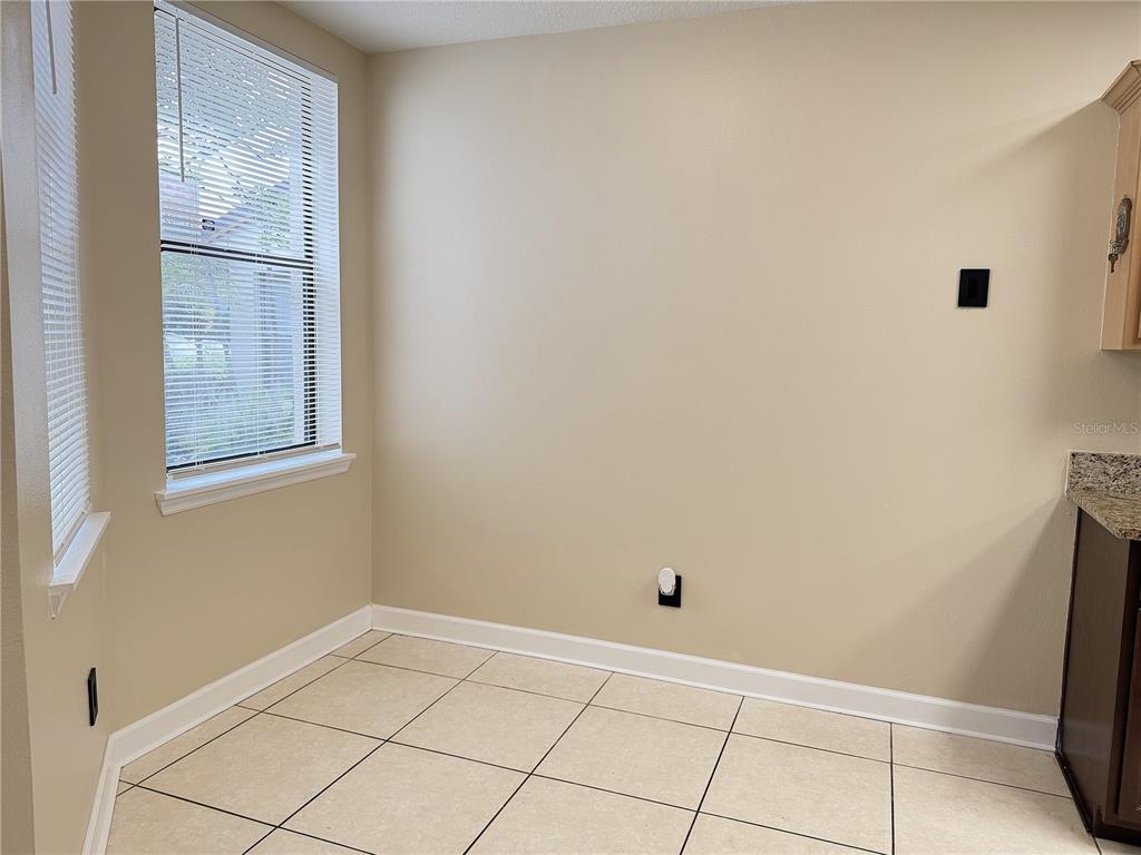 A small dining area features beige walls, light-colored floor tiles, and a window with blinds — 4125 S LAKE ORLANDO PARKWAY UNIT 4125, ORLANDO, FL