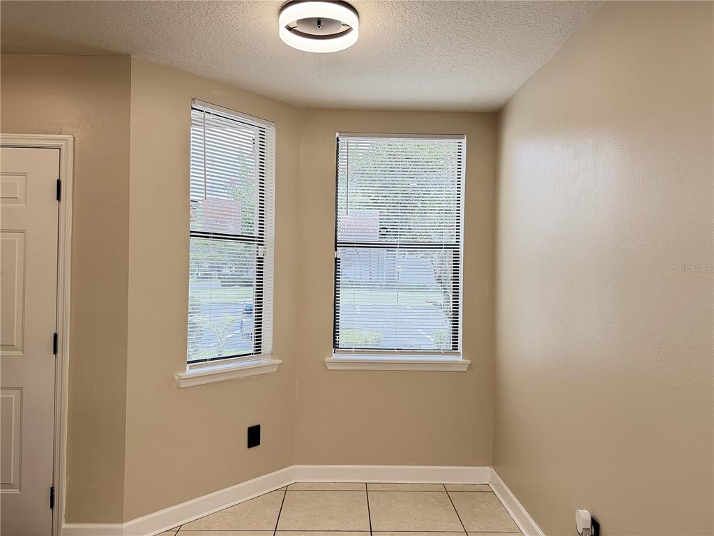A room with beige walls, tile flooring, two windows with blinds, and a ceiling light fixture — 4125 S LAKE ORLANDO PARKWAY UNIT 4125, ORLANDO, FL