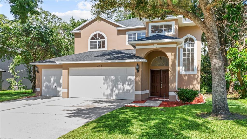 A two-story house with a tan stucco exterior, a three-car garage, and a front entryway — 2247 MOUNTAIN SPRUCE STREET, OCOEE, FL