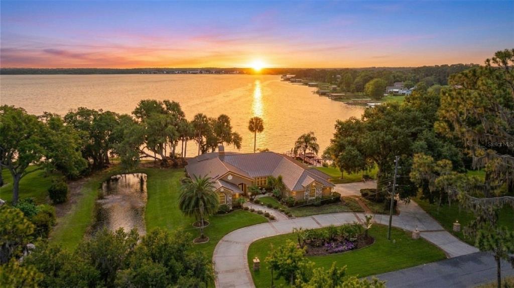 An aerial view of a lakefront house with a circular driveway and a small pond — 29650 SQUIRREL POINT ROAD, TAVARES, FL