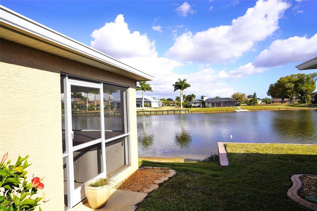 A view from a patio looking out over a lake toward neighboring houses — 12760 SW LAKE SIDE DRIVE, ARCADIA, FL