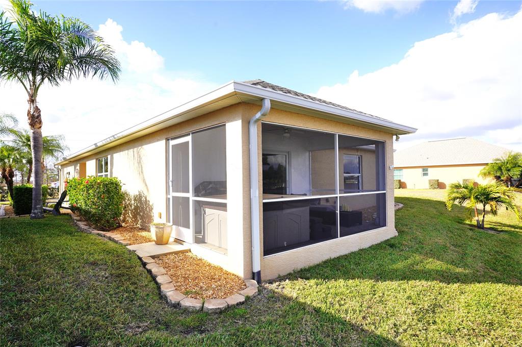 A tan house features a screened-in porch with a hot tub and a palm tree — 12760 SW LAKE SIDE DRIVE, ARCADIA, FL