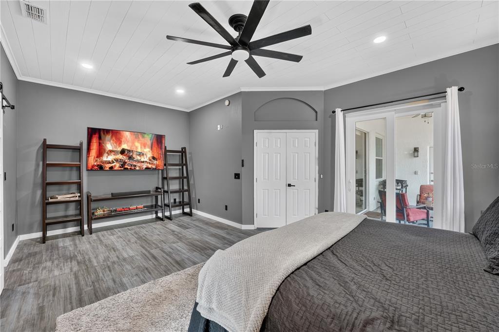 A bedroom features a large bed, a dark dresser with a television, and a small desk — 13686 CRYSTAL RIVER DRIVE, ORLANDO, FL