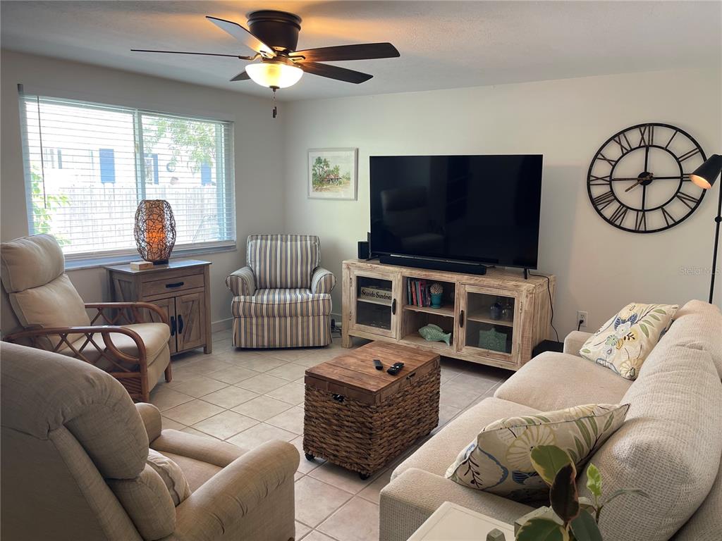 A kitchen features white cabinets, stainless steel appliances, tile flooring, and a small dining table — 2904 AVENUE B, BRADENTON BEACH, FL