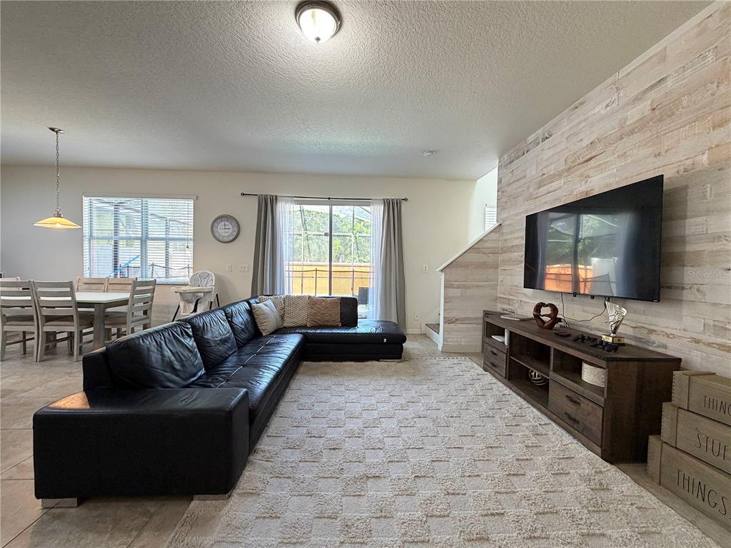 A two-story stucco townhouse with a red exterior, a palm tree, and a front walkway — 720 LAS FUENTES DRIVE, KISSIMMEE, FL
