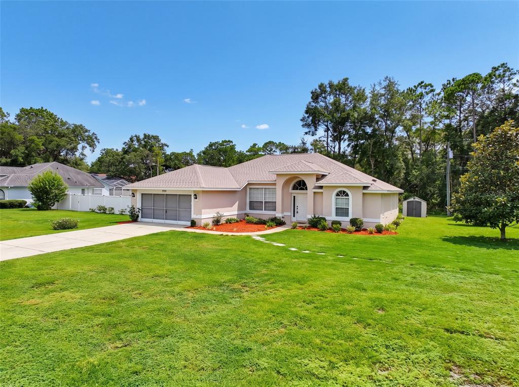 A single-story house with a beige exterior, a two-car garage, and a large front lawn — 9700 N KENDALL WAY, CITRUS SPRINGS, FL