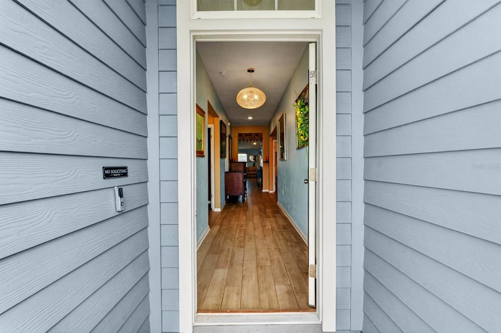 A view through an open front door into a hallway with light blue walls — 81 HICKORY RIDGE ROAD, ST AUGUSTINE, FL