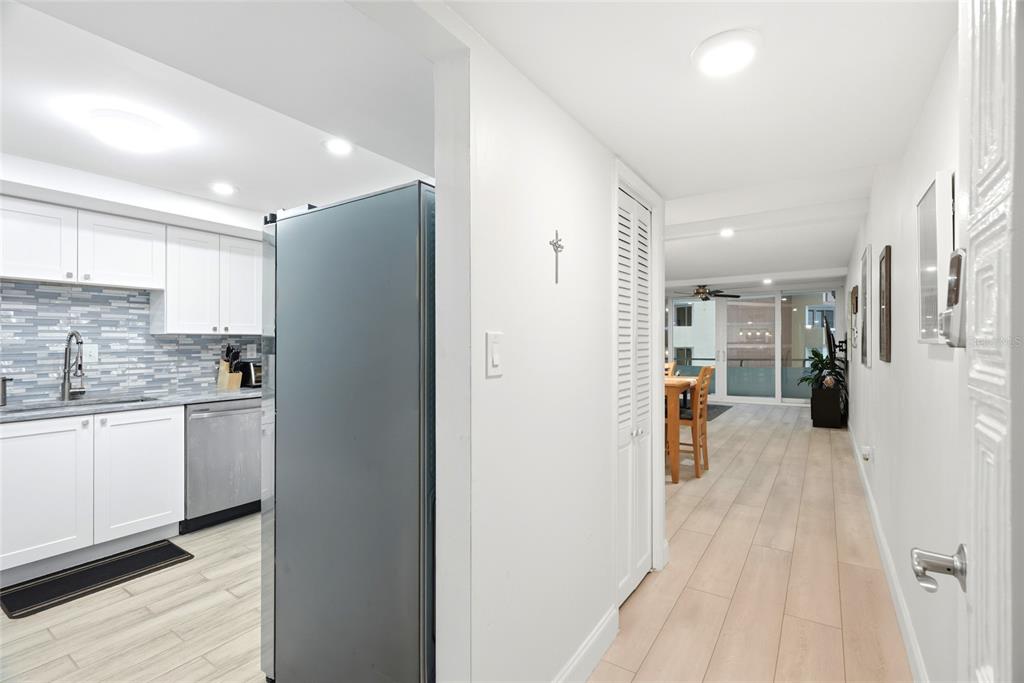 A view from a hallway looking into a kitchen and a dining area with balcony — 17920 GULF BOULEVARD UNIT 1502, ST PETERSBURG, FL