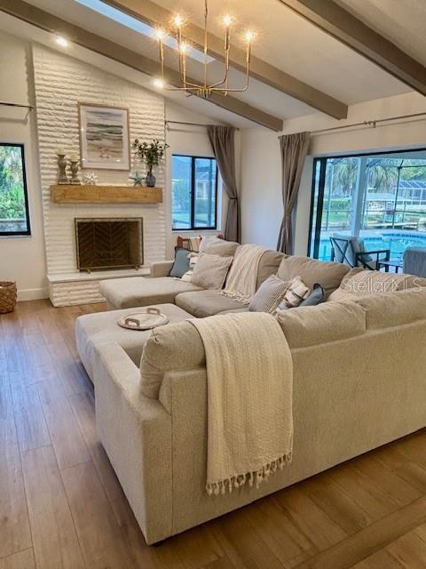 A living room features a white brick fireplace, a large sectional sofa, and vaulted ceilings — 13 COLONIA COURT, PALM COAST, FL