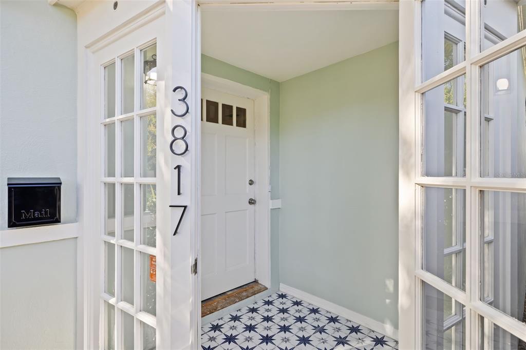 A covered entryway features a white door, light green walls, and patterned tile flooring — 3817 W BAY TO BAY BOULEVARD, TAMPA, FL