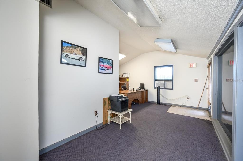 An office space features a desk, a printer on a stand, and two framed car pictures — 377 E STATE ROAD 434, LONGWOOD, FL