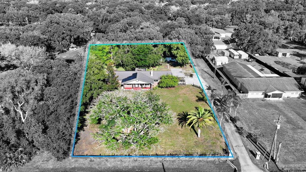 An aerial view shows a house on a large, tree-filled lot with a fenced perimeter — 298-300 ORANGE AVENUE, ST CLOUD, FL