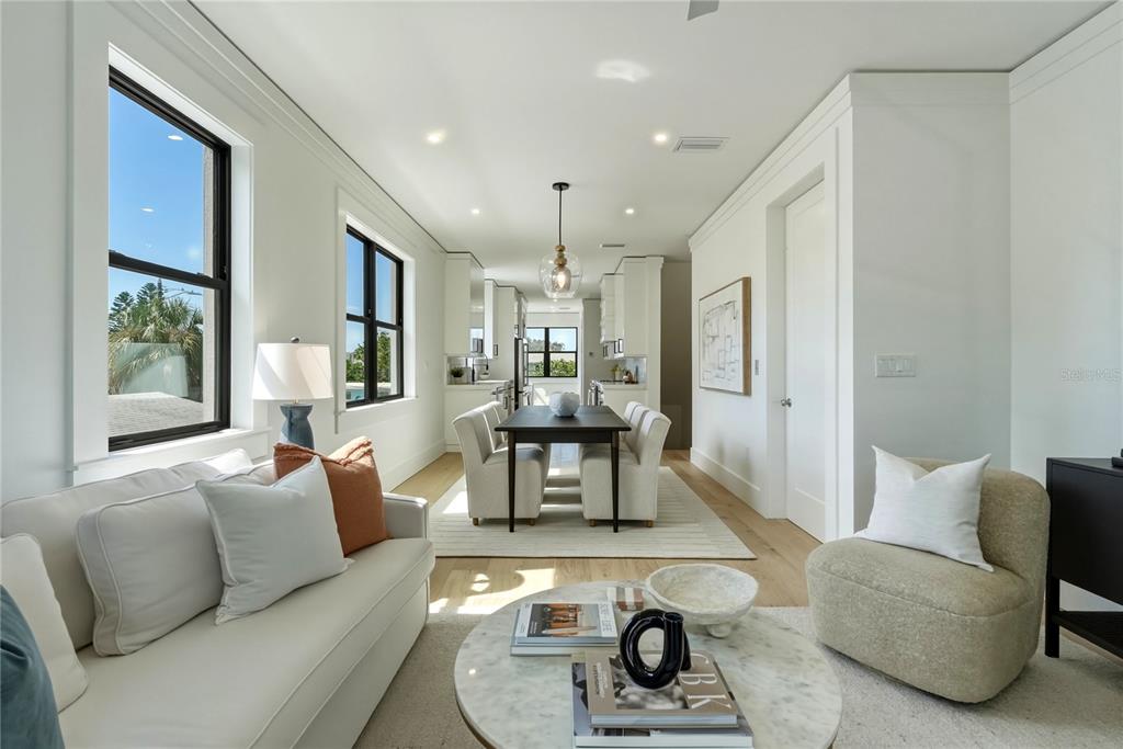 A bright living and dining area features white walls, light wood floors, and modern furniture — 205 BATES AVENUE UNIT B, INDIAN ROCKS BEACH, FL