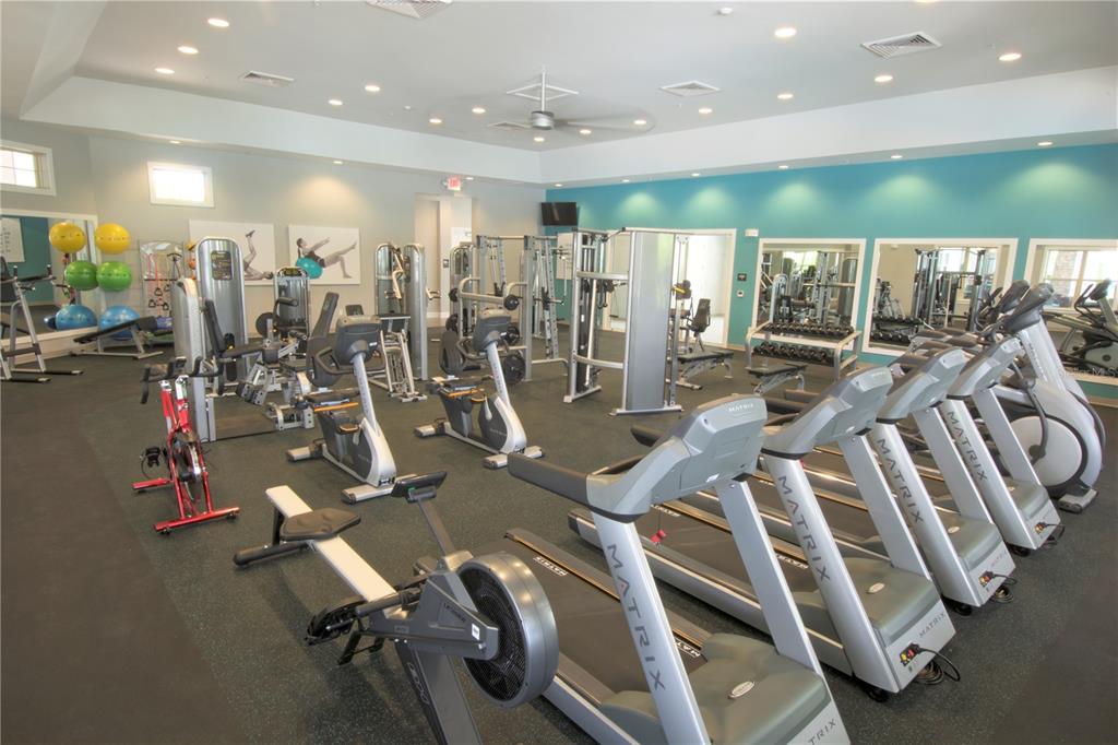 A gym room features multiple Matrix treadmills, stationary bikes, a rowing machine, and weight equipment — 11881 SHINE VIEW LANE, WINTER GARDEN, FL