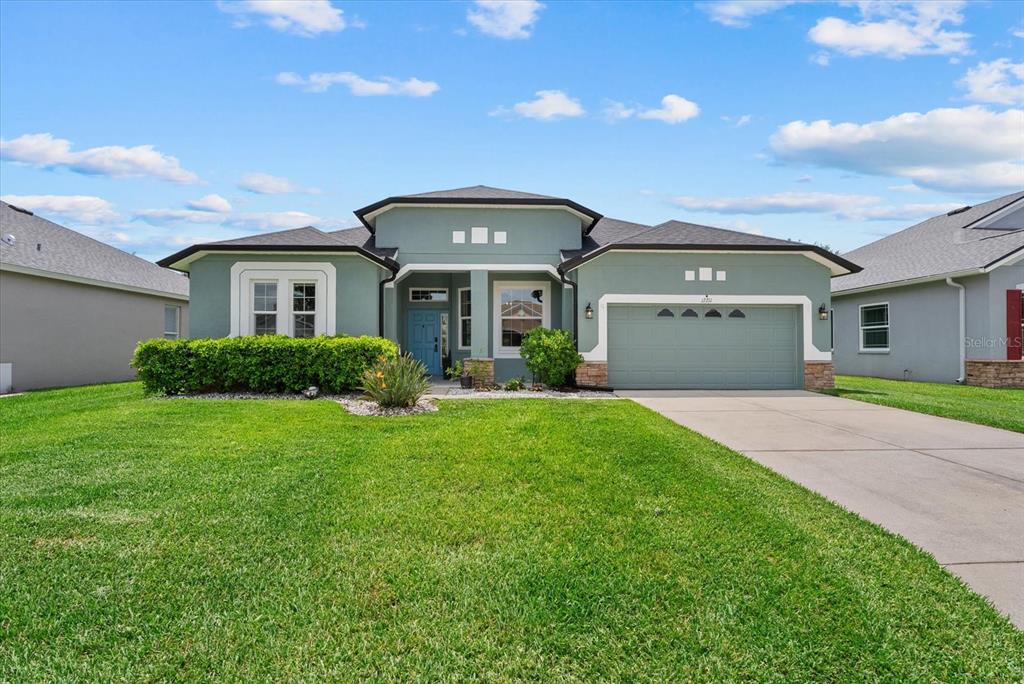 A single-story house with a green exterior, a two-car garage, and a front lawn — 12211 23RD STREET E, PARRISH, FL