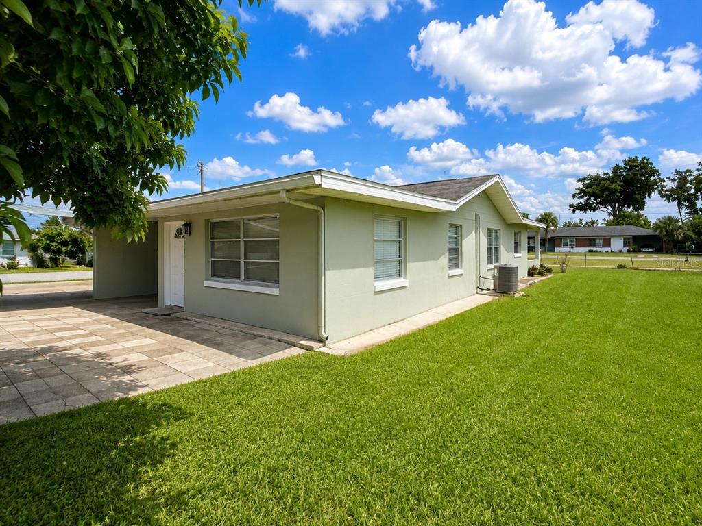A light green single-story house with a paved carport and a large grassy yard — 5039 OLD CHENEY HIGHWAY UNIT B, ORLANDO, FL