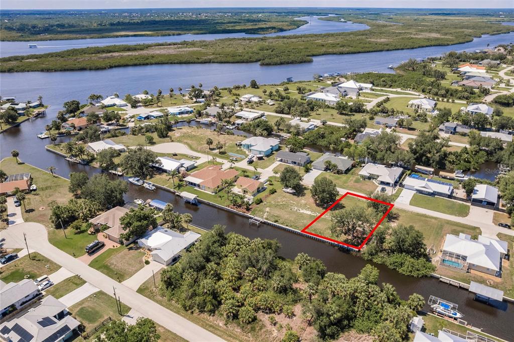 An aerial view shows a vacant waterfront lot outlined in red along a canal — 28451 SILVER PALM DRIVE, PUNTA GORDA, FL