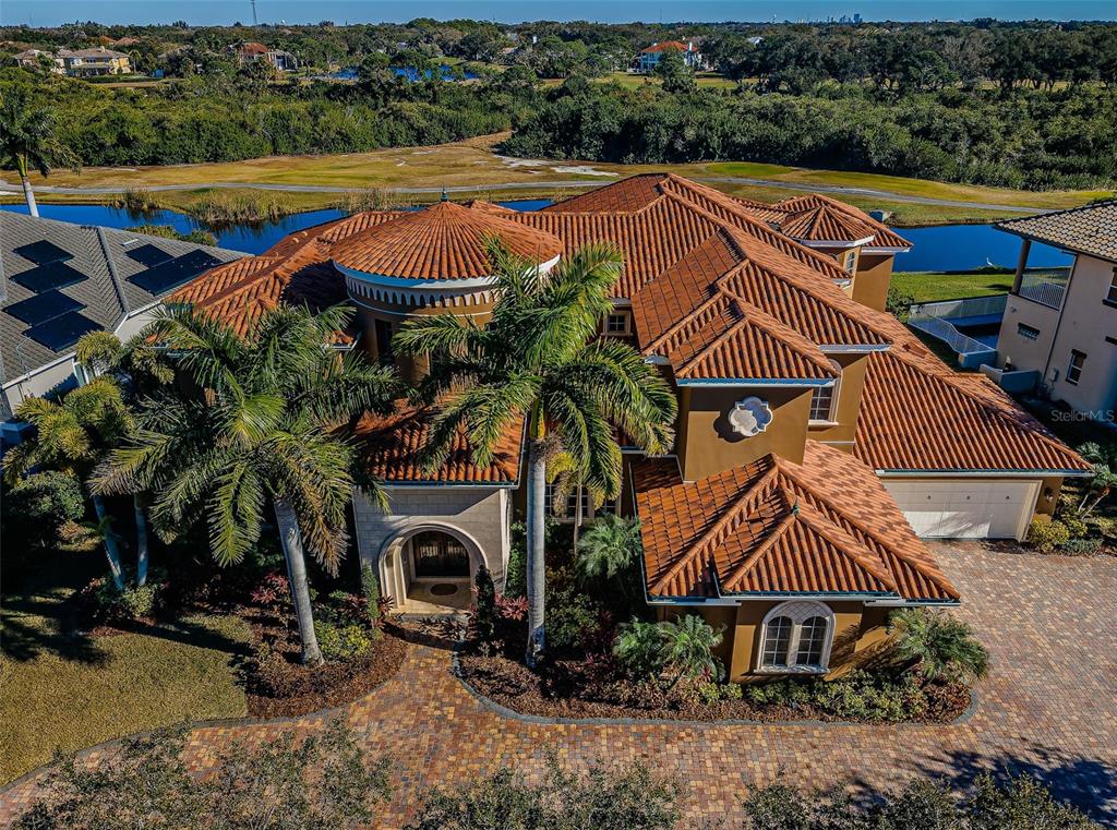 An aerial view of a multi-story Mediterranean-style house with a terracotta tile roof and driveway — 9209 SILVERTHORN ROAD, SEMINOLE, FL