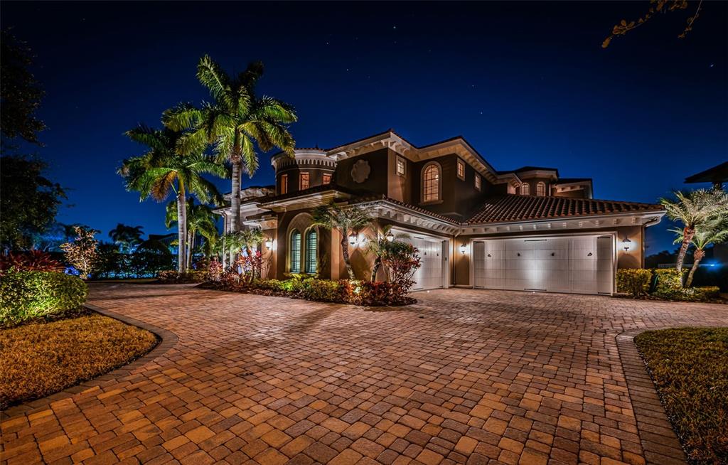 A two-story house with a paved driveway, palm trees, and garage doors at night — 9209 SILVERTHORN ROAD, SEMINOLE, FL