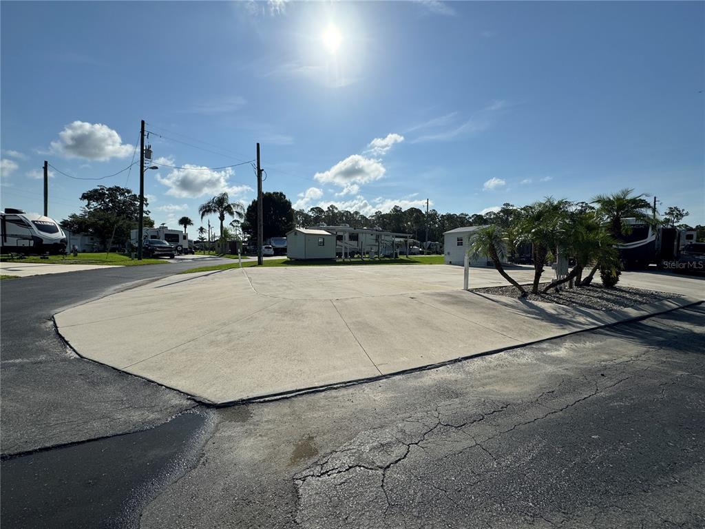A vacant concrete pad for an RV or mobile home sits in a sunny lot — 1389 SHIPWRECK LANE, ST CLOUD, FL