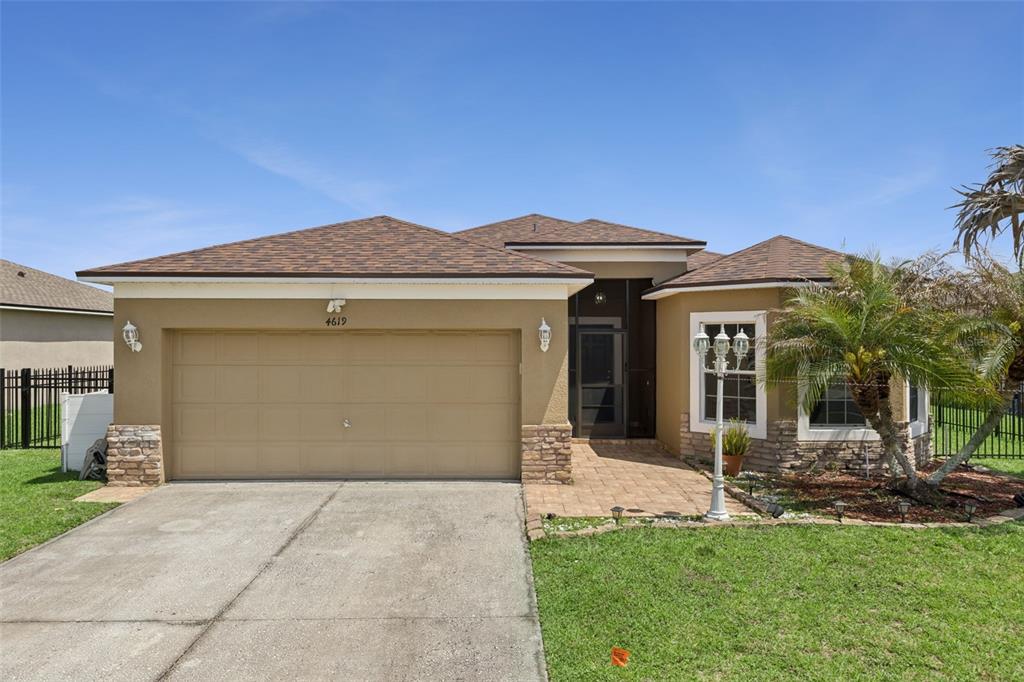 An aerial view of a gated residential community entrance lined with numerous tall palm trees — 4619 CABALERRO TRAIL, KISSIMMEE, FL