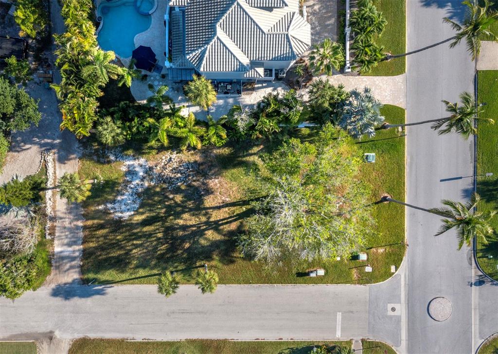 An aerial view shows a vacant residential lot next to a house with a pool — 641 BROADWAY STREET, LONGBOAT KEY, FL