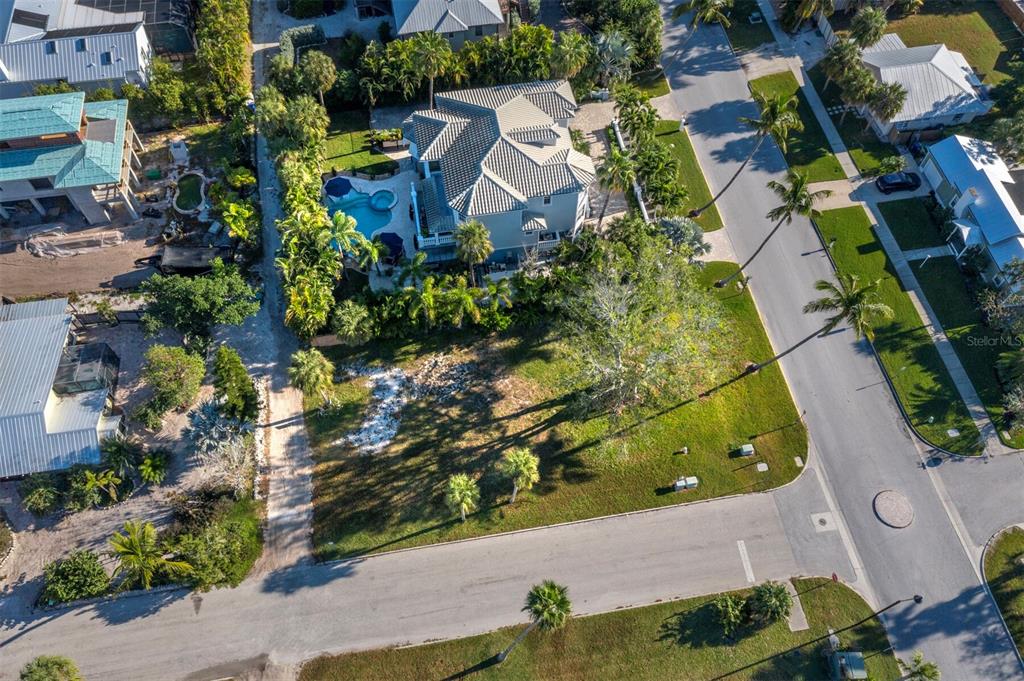 An aerial view shows a residential property with a pool and a large vacant lot — 641 BROADWAY STREET, LONGBOAT KEY, FL