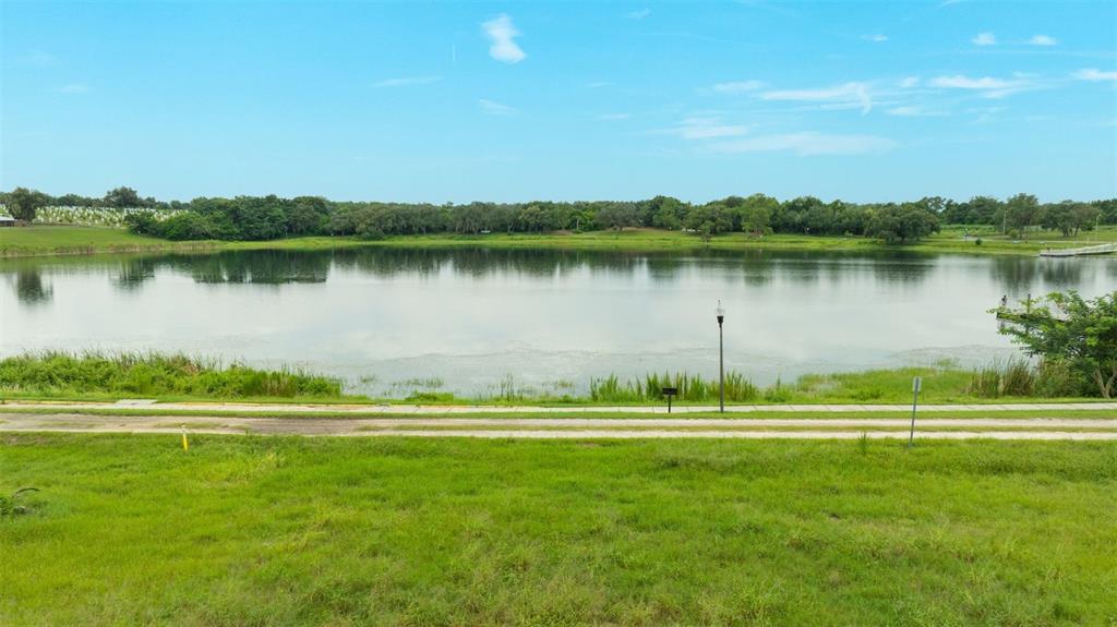 A view of a calm lake with a grassy foreground and a walking path — 0 E LAKE MENZIE BOULEVARD Lot 14, DUNDEE, FL