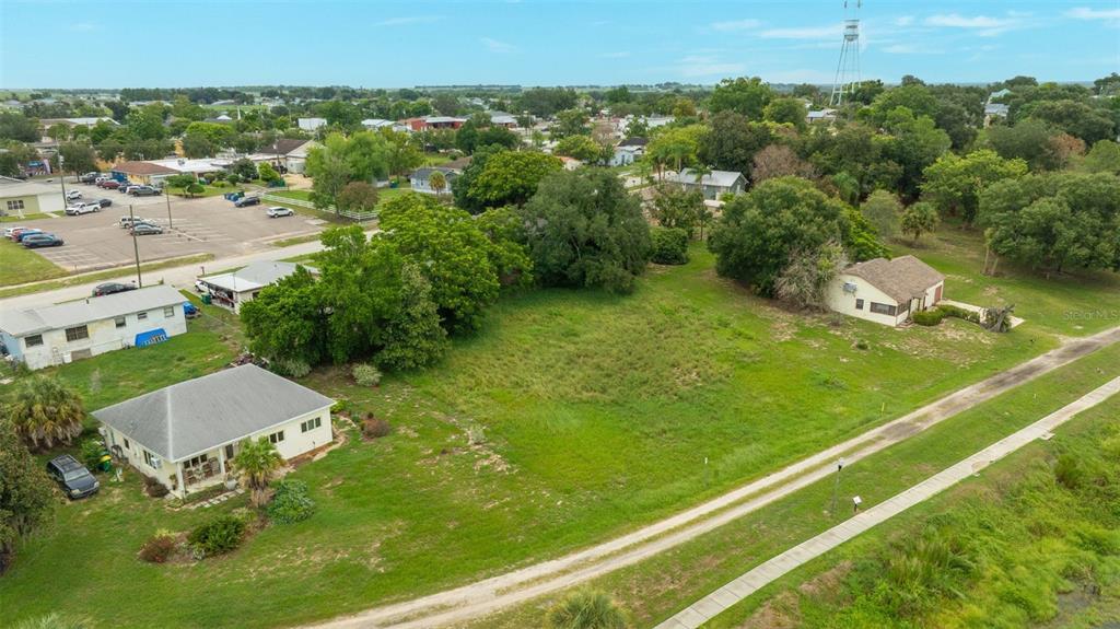 An aerial view shows a grassy vacant lot situated between two houses and a parking lot — 0 E LAKE MENZIE BOULEVARD Lot 14, DUNDEE, FL