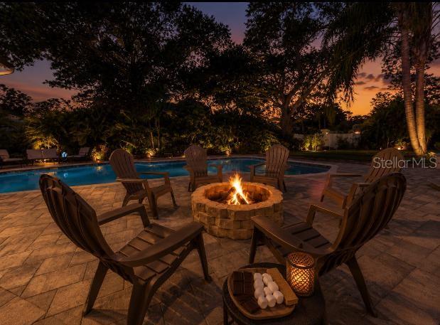 A backyard features a swimming pool, a putting green, and a multi-level beige house — 1584 OAK LANE, CLEARWATER, FL