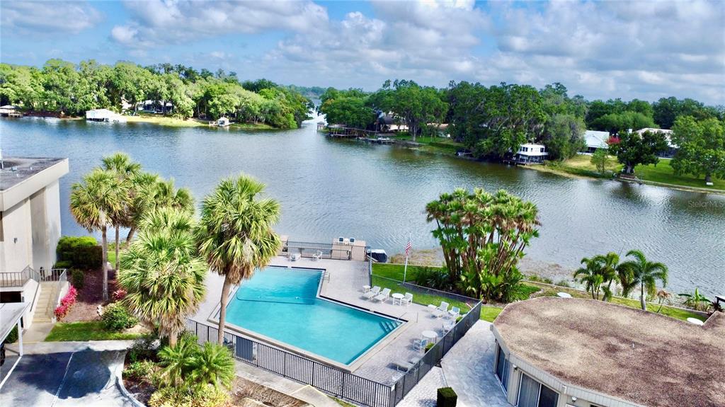 An aerial view shows a swimming pool on a patio overlooking a lake — 404 E ORLANDO AVENUE UNIT 8B, OCOEE, FL