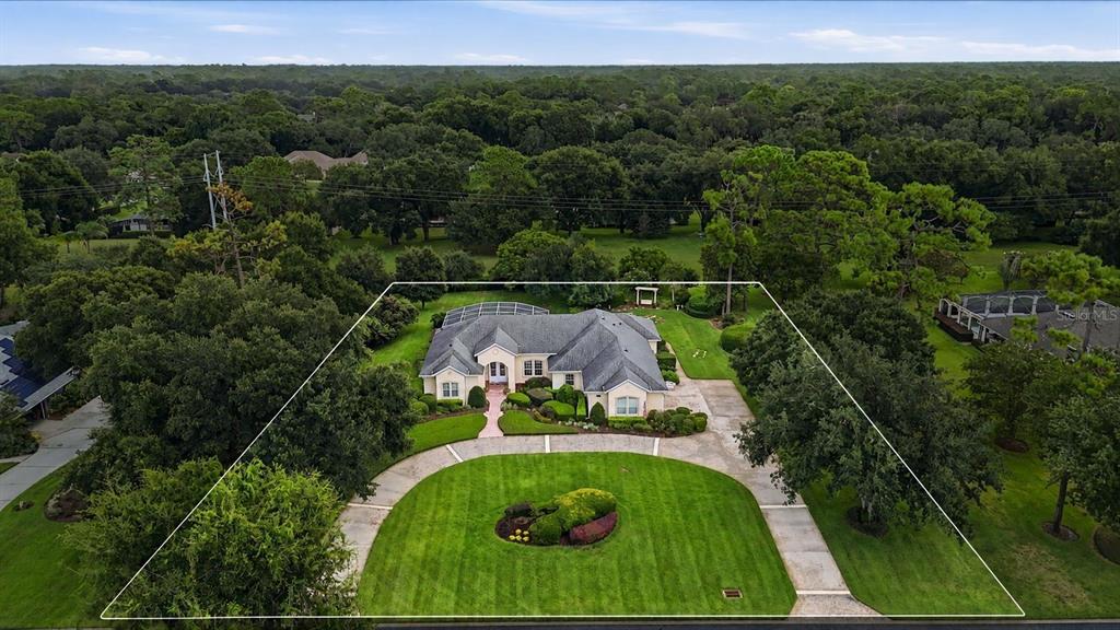 An aerial view of a single-story house with a circular driveway and a large lawn — 1681 TIMBER EDGE DRIVE, DELAND, FL