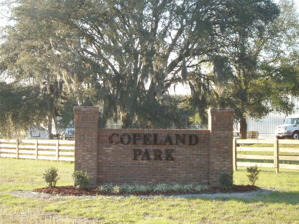 A brick sign reading Copeland Park stands in front of a large tree and fence — TBD NW 126TH TERRACE, ALACHUA, FL