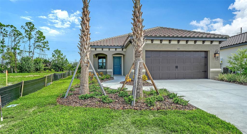 A single-story house with a brown garage, blue front door, and two palm trees outside — 345 POTENZA LOOP, NOKOMIS, FL