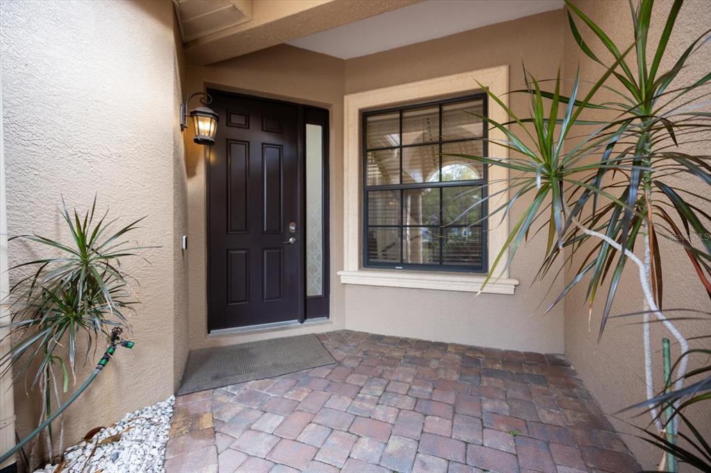 A front entryway with a dark door, a window, and a paved porch area — 6120 E 27 STREET E, ELLENTON, FL