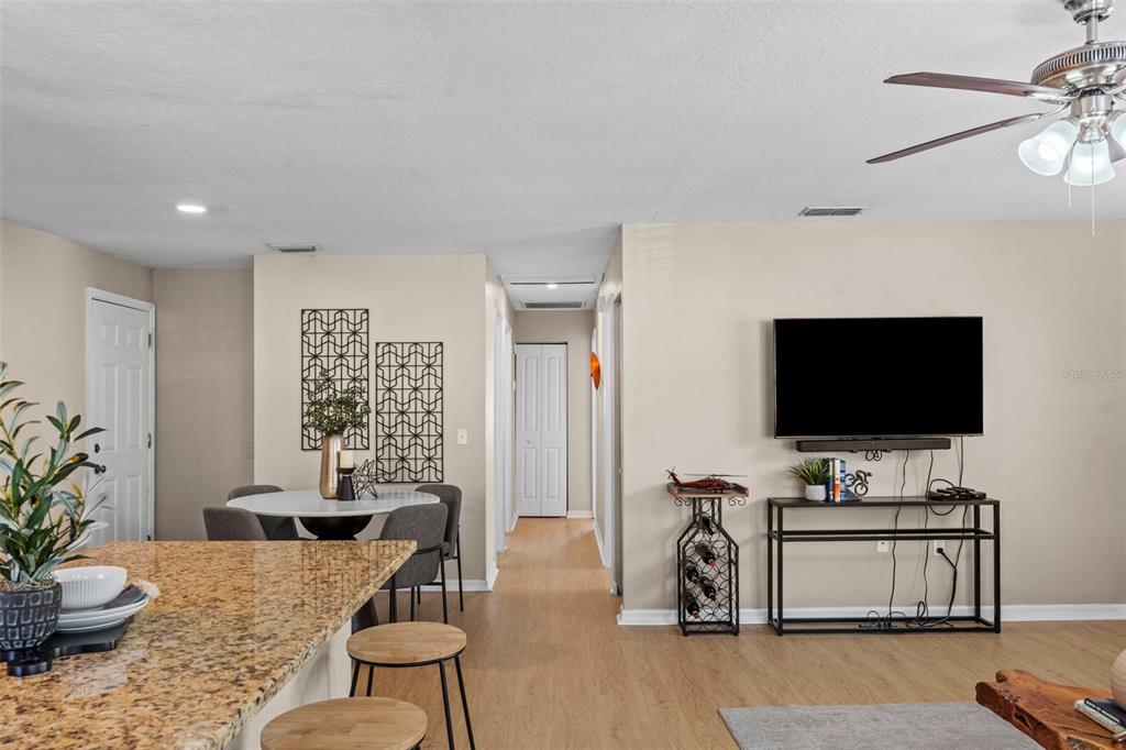A kitchen island with granite countertops overlooks a dining area and a living room space — 7610 S SHERRILL STREET, TAMPA, FL