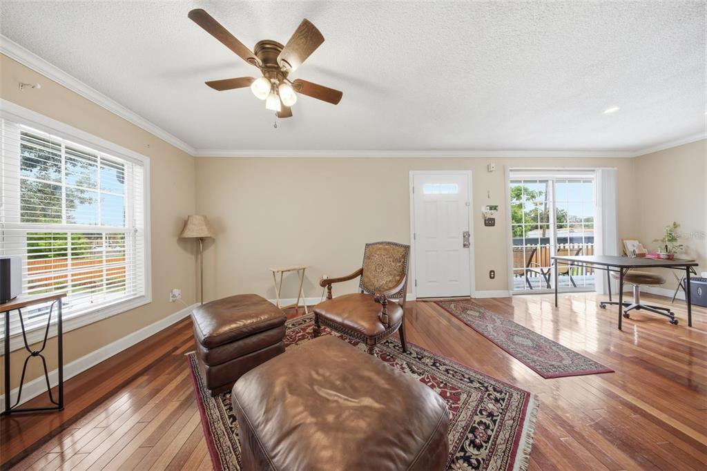 A living room features hardwood floors, a ceiling fan, a leather chair, and a sliding door — 4890 CONWAY ROAD UNIT 66, ORLANDO, FL