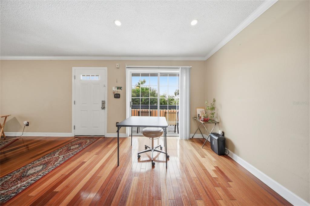 A room with hardwood floors, a white door, a sliding glass door, and a desk — 4890 CONWAY ROAD UNIT 66, ORLANDO, FL