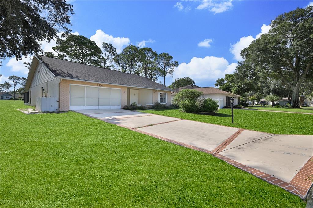 A single-story house with a brick facade, a two-car garage, and a concrete driveway — 2376 BENT PINE COURT, SPRING HILL, FL